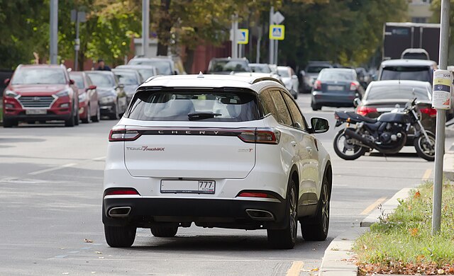 Белый Chery Tiggo 7 Pro Max едет по улице, виз сзади